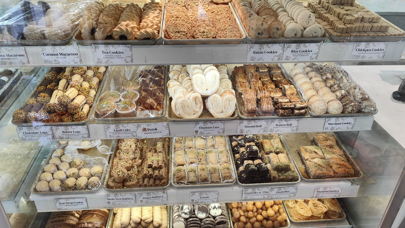 Rows of cookies, baklava, rolls, and pastries inside Classic Bakery