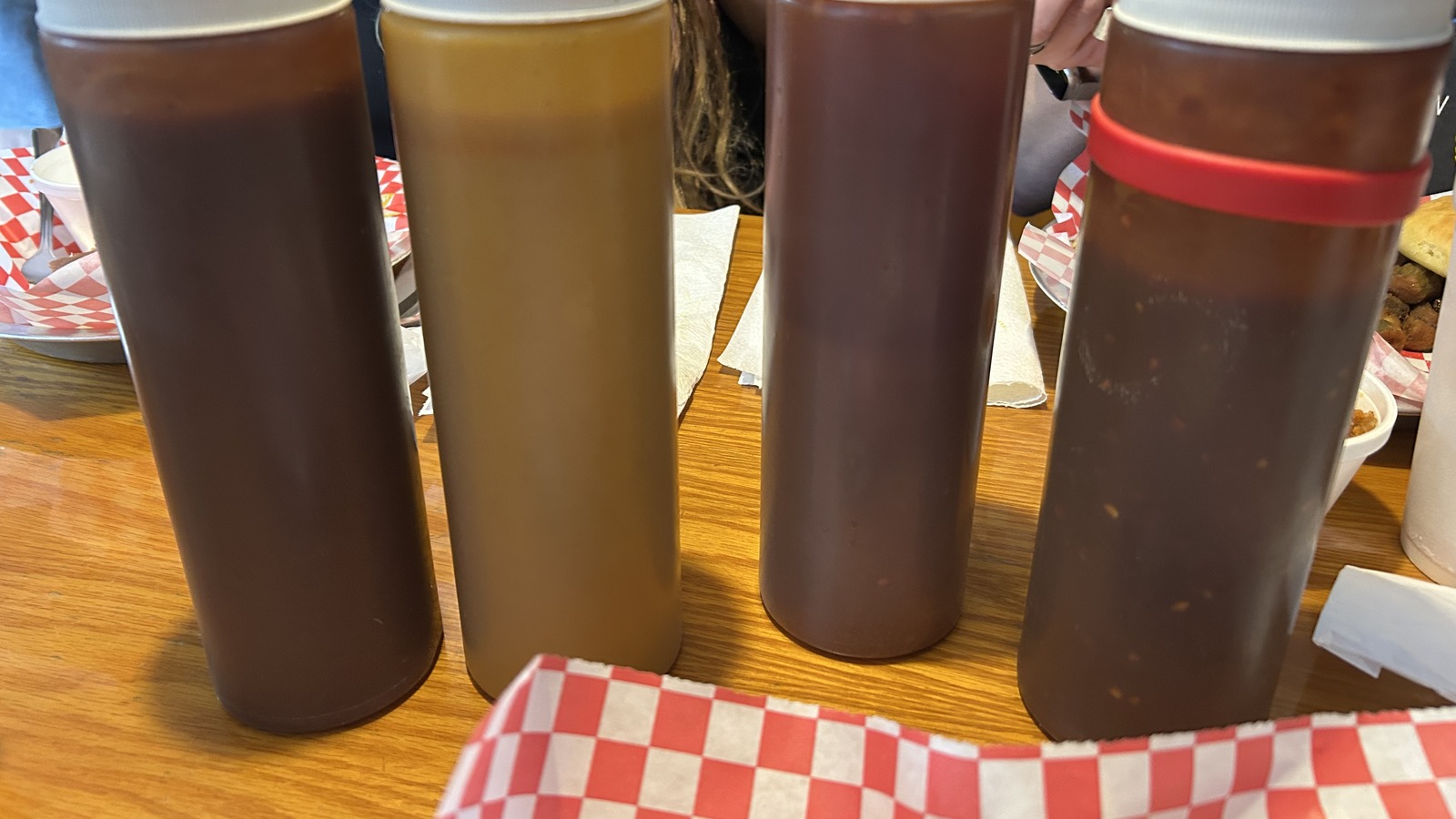 Four sauce bottles lined up on a table at JD's Smokehouse