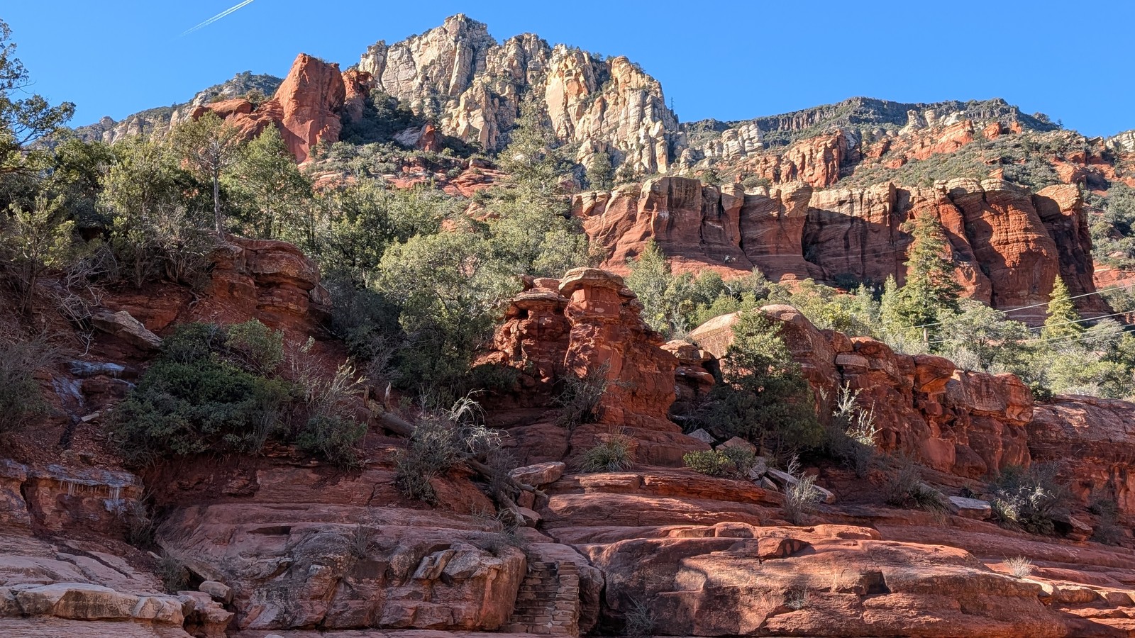 Layered red sandstone shelves with high canyon walls above Oak Creek Canyon