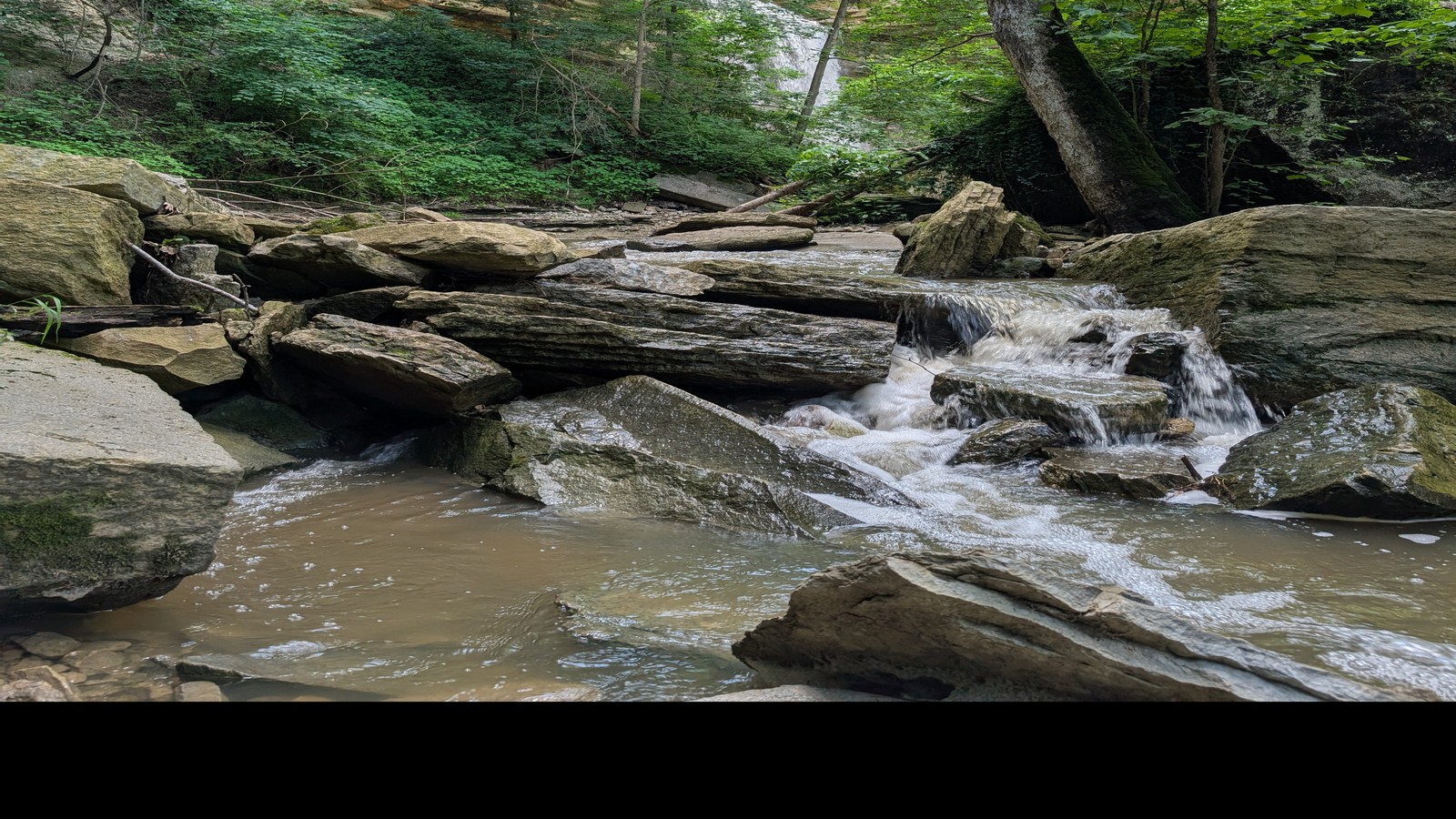 Boulders, rushing creek, and a cliffside waterfall deep in the Clifty canyon.