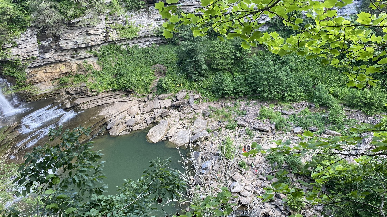 High overlook above the Cummins Falls gorge with layered rock, water, and dense greenery.