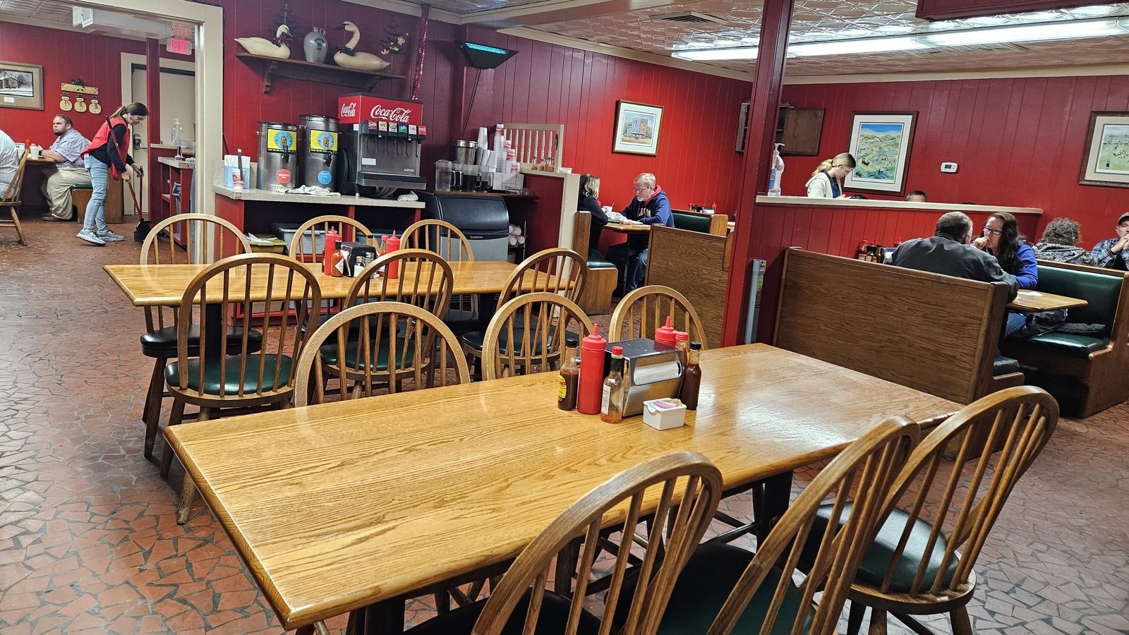 Red-paneled dining room with wood tables and booths inside Lexington Barbecue