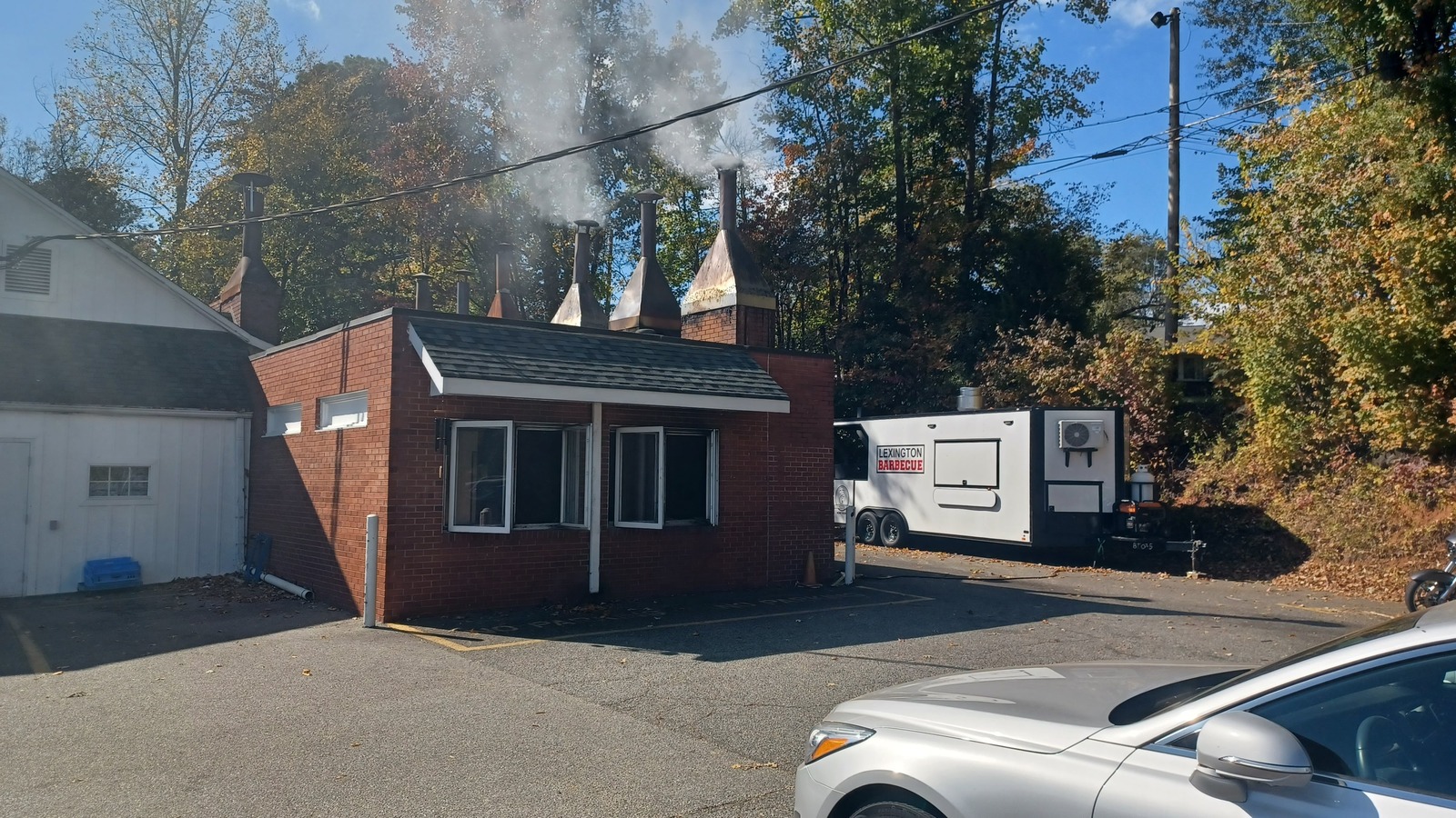 Brick pit house and smoking chimneys behind Lexington Barbecue