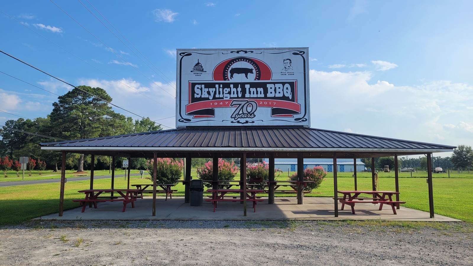 Roadside Skylight Inn BBQ sign beside the open-air picnic shelter and broad green lawn