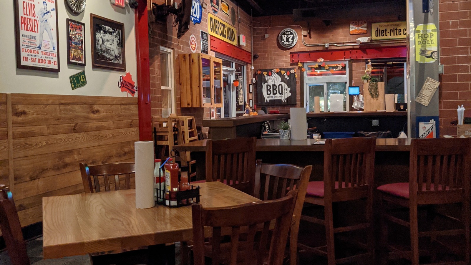 Wall art, wood paneling, and a quiet dining corner inside Midwood Smokehouse.
