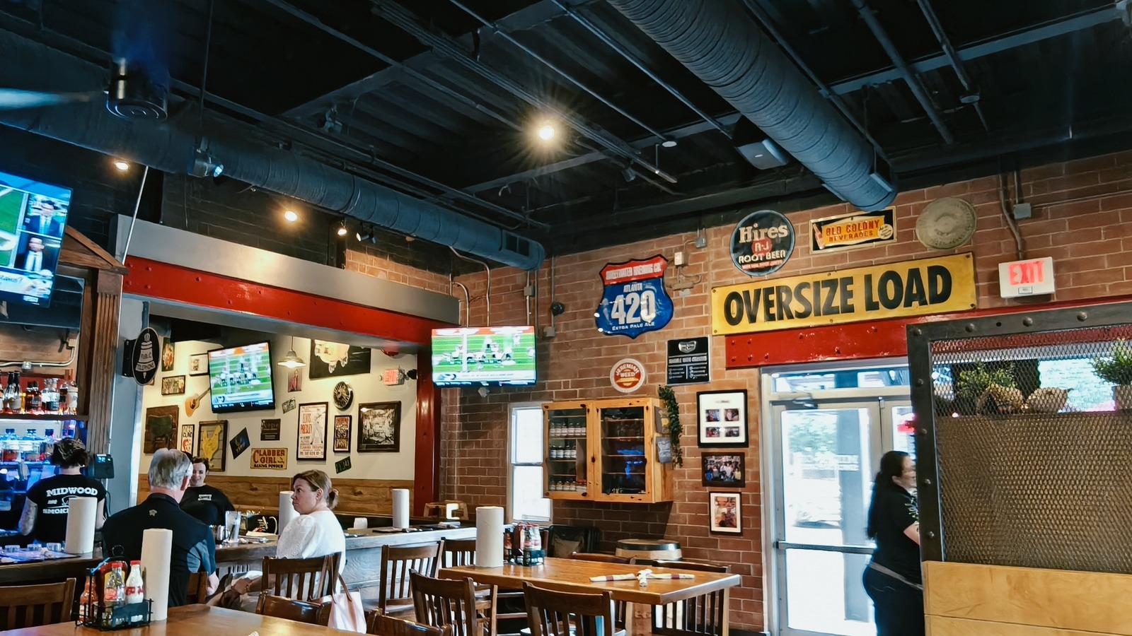 Vintage signs and brick walls inside Midwood Smokehouse in Plaza Midwood.