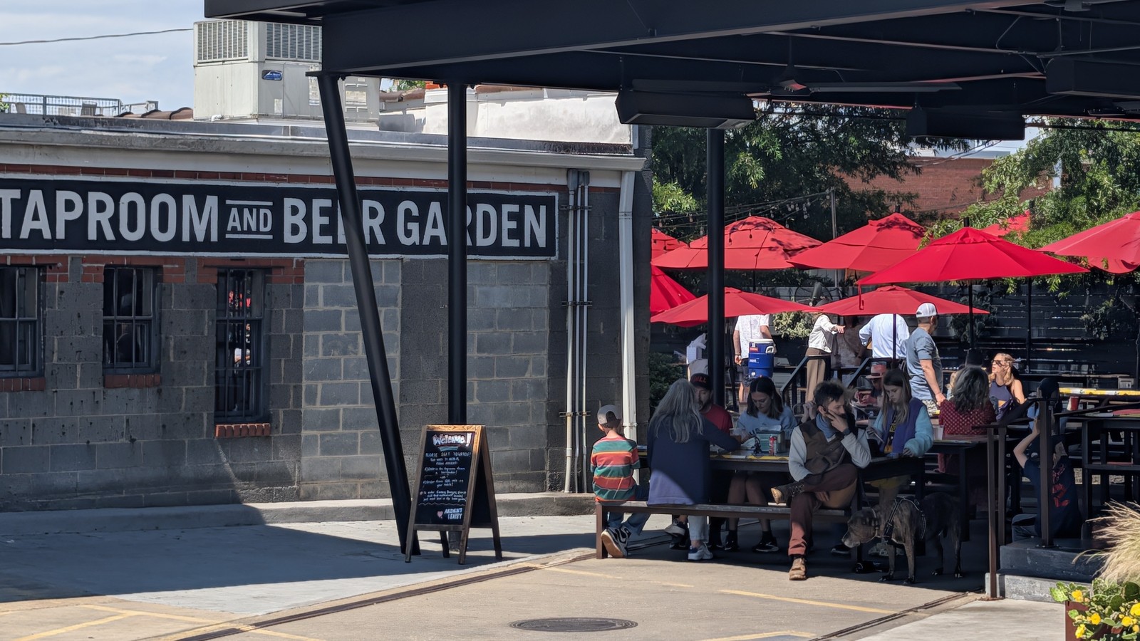 Taproom and beer garden patio with red umbrellas beside ZZQ Texas Craft Barbeque