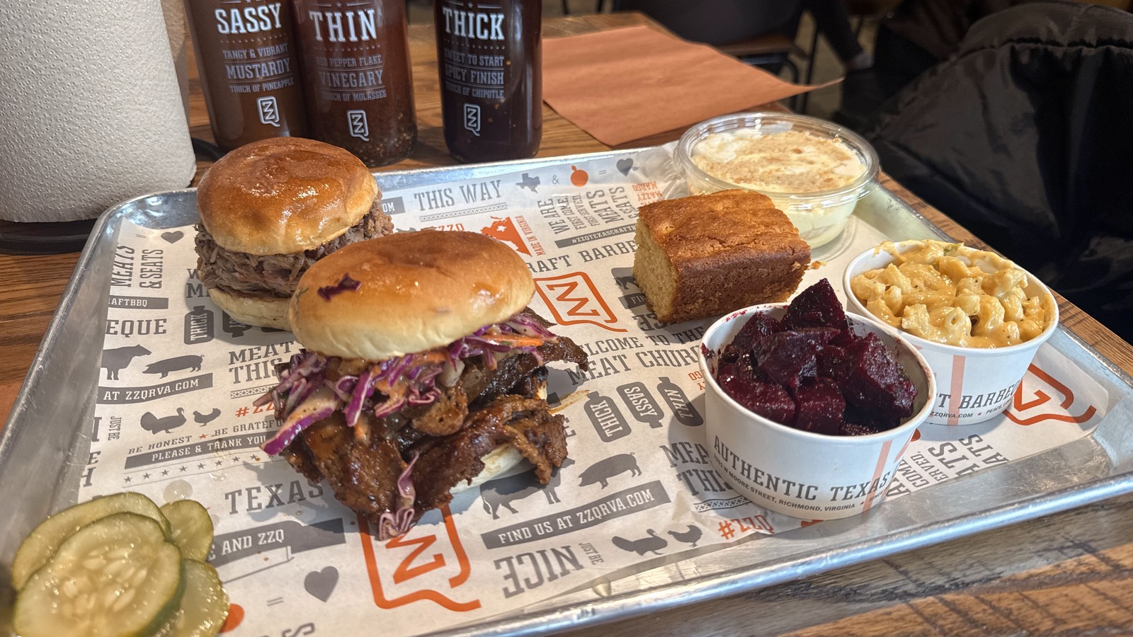 Two sandwiches, mac and cheese, beets, cornbread, and house sauces on a tray at ZZQ Texas Craft Barbeque
