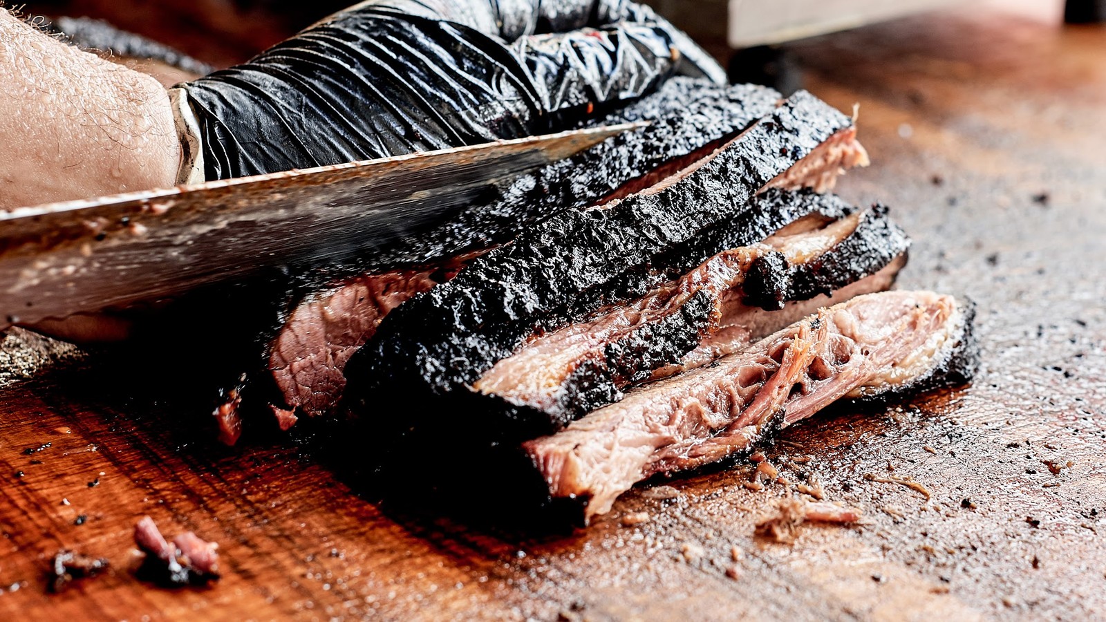 Close view of brisket slices resting on a wooden cutting board at ZZQ Texas Craft Barbeque