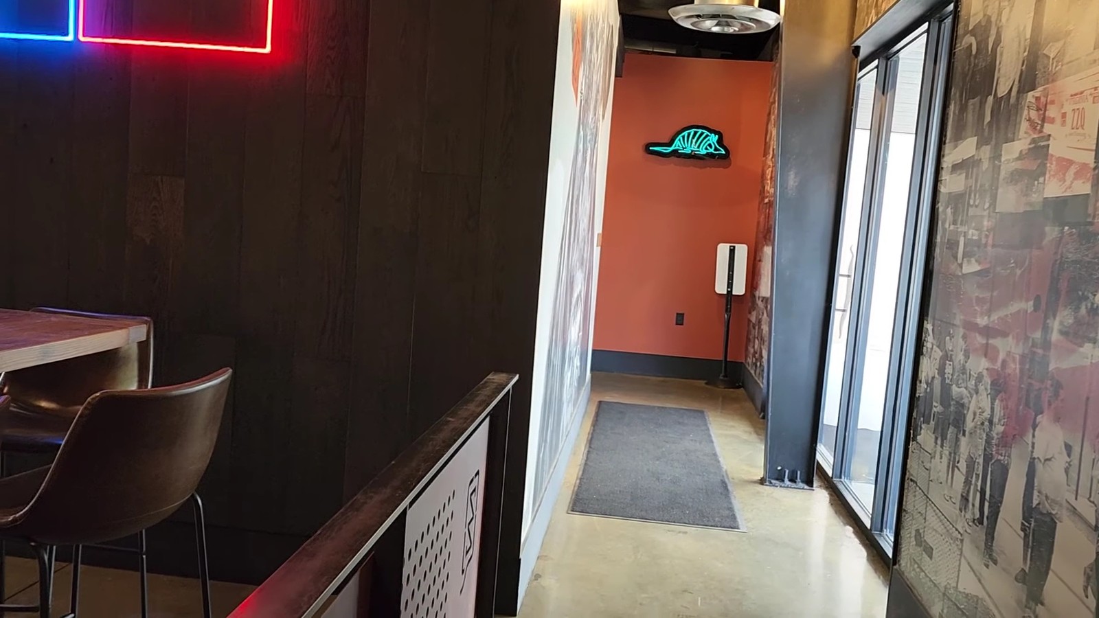 Armadillo neon sign glowing at the end of a side hallway inside ZZQ Texas Craft Barbeque