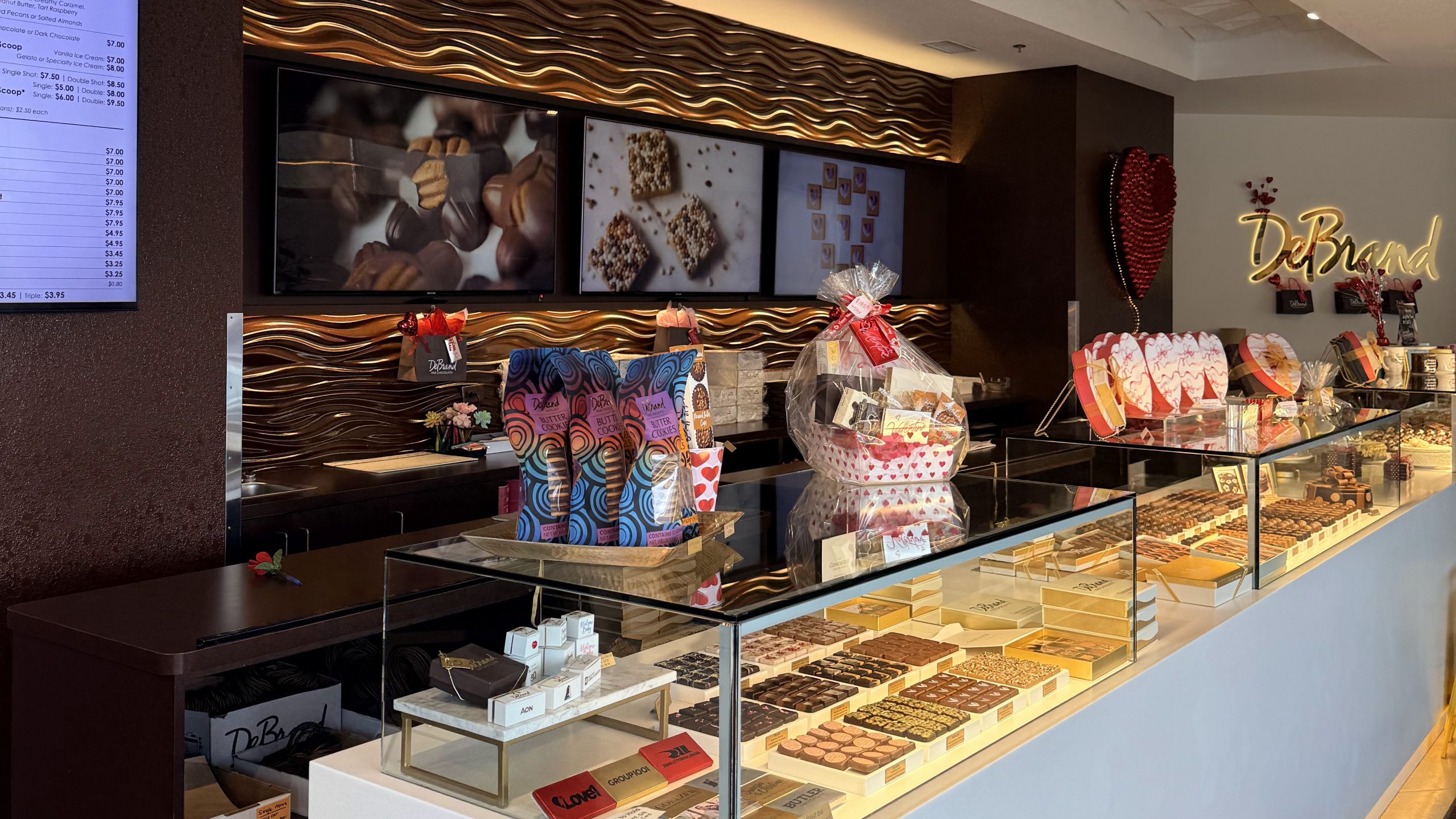 Chocolate cases and glowing wall details inside DeBrand Fine Chocolates