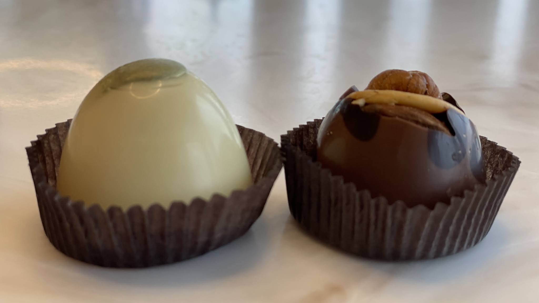 Two glossy DeBrand chocolates set out piece by piece