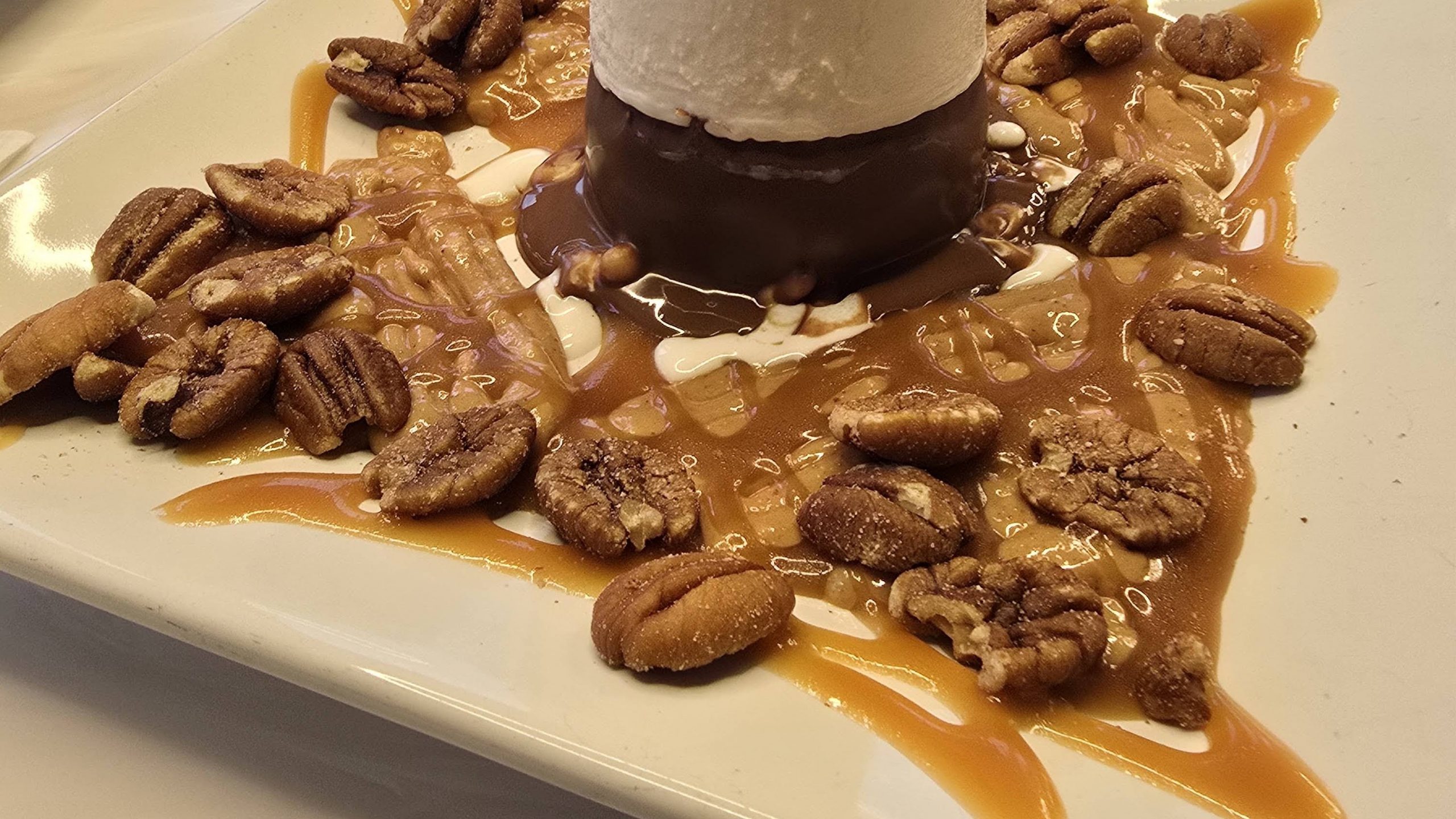 Caramel-and-pecan sundae plated at DeBrand Fine Chocolates