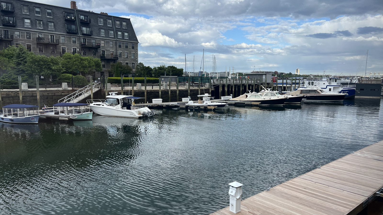 boats and docks beside Boston Sail Loft on a bright harbor afternoon