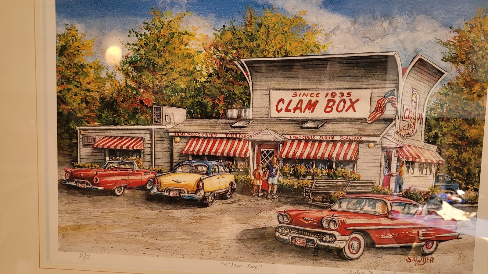 Framed painting of the Clam Box with classic cars and red-striped awnings.