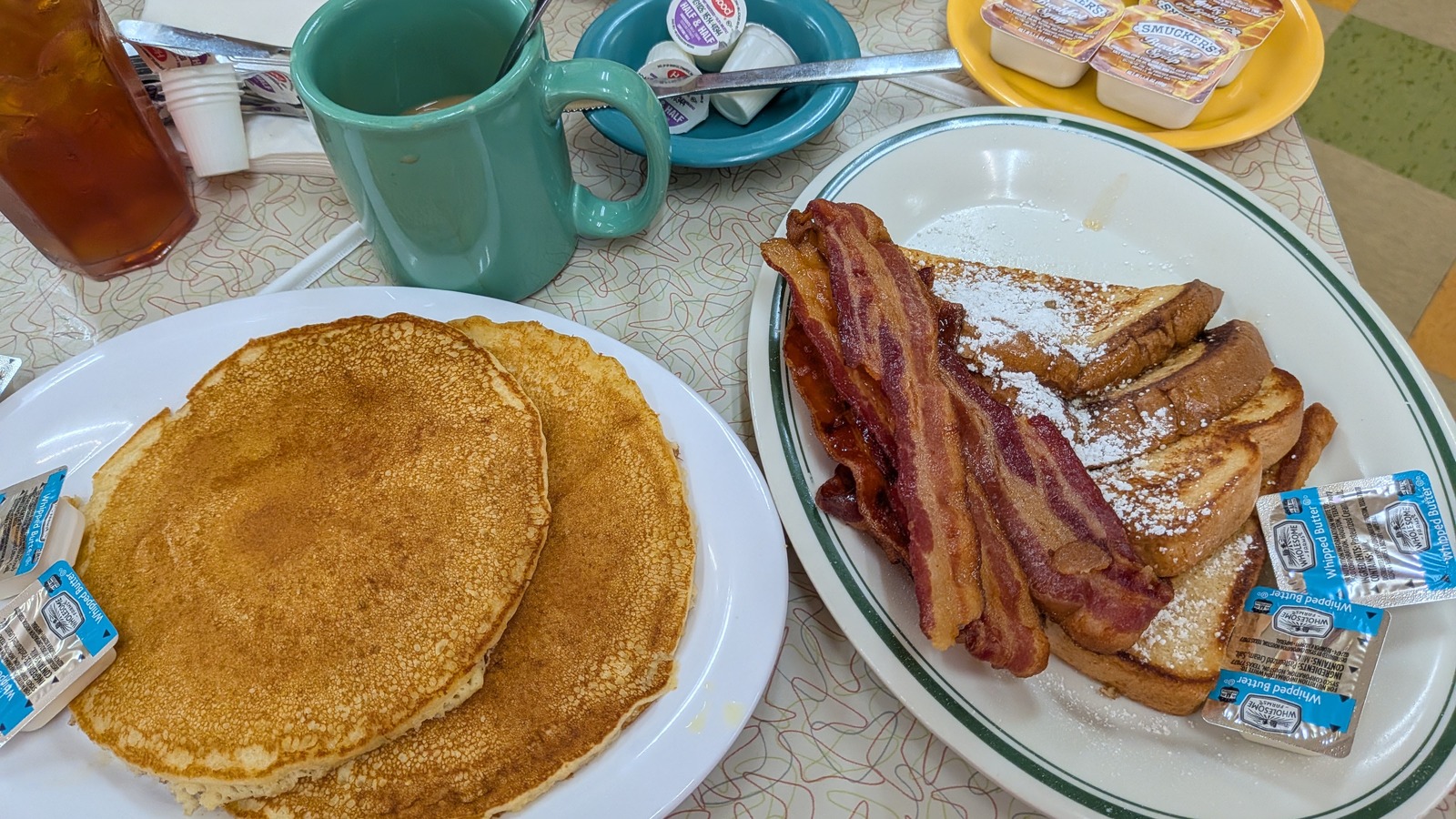Pancakes, bacon, toast, and a tablewide breakfast spread at Silver Skillet