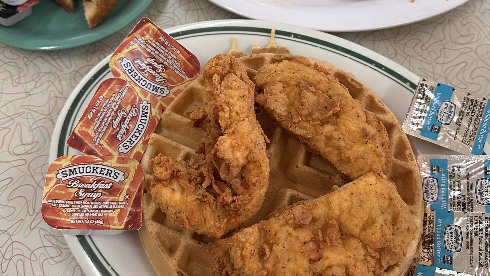 Chicken and waffles served with syrup cups on a Silver Skillet plate