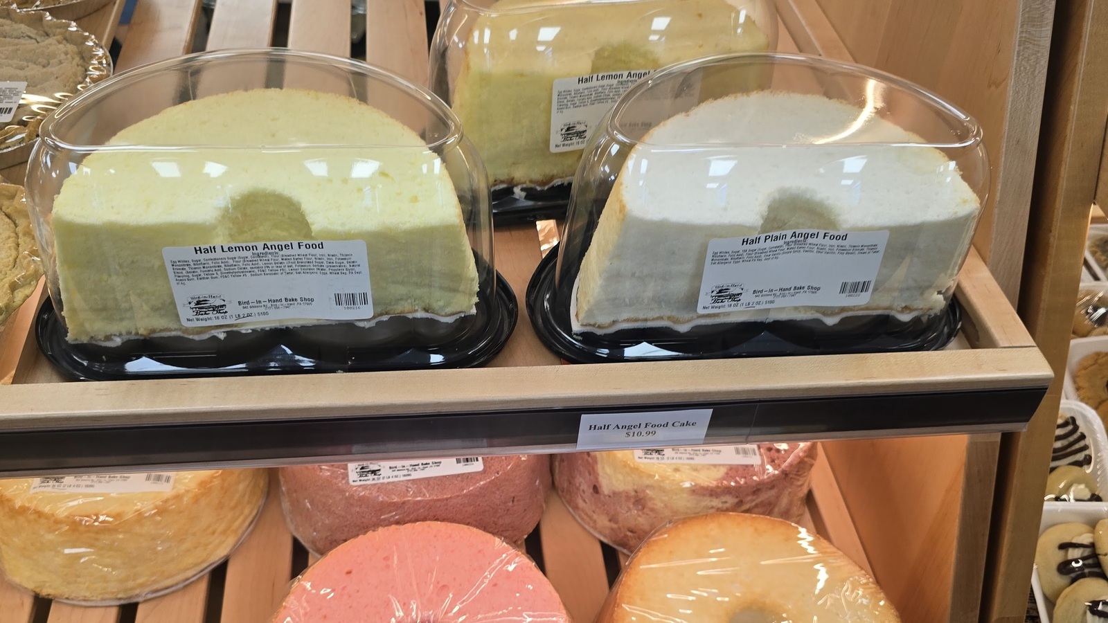 Angel food cakes and round layer cakes on bakery shelves at Bird-in-Hand Bake Shop