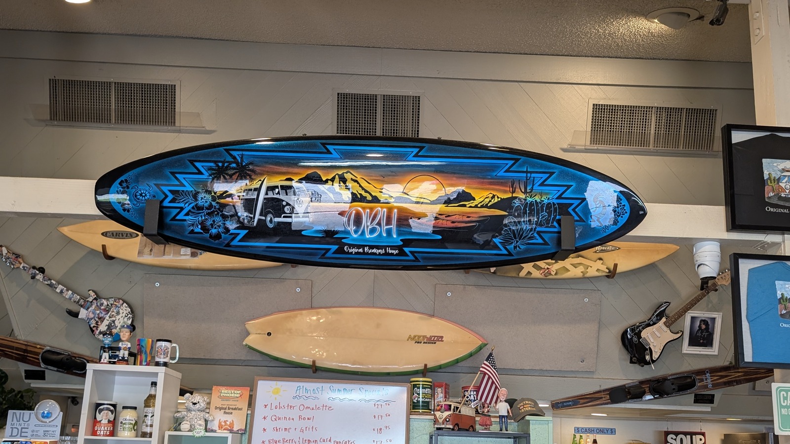Surfboards, guitars, and the specials board above the counter at Original Breakfast House
