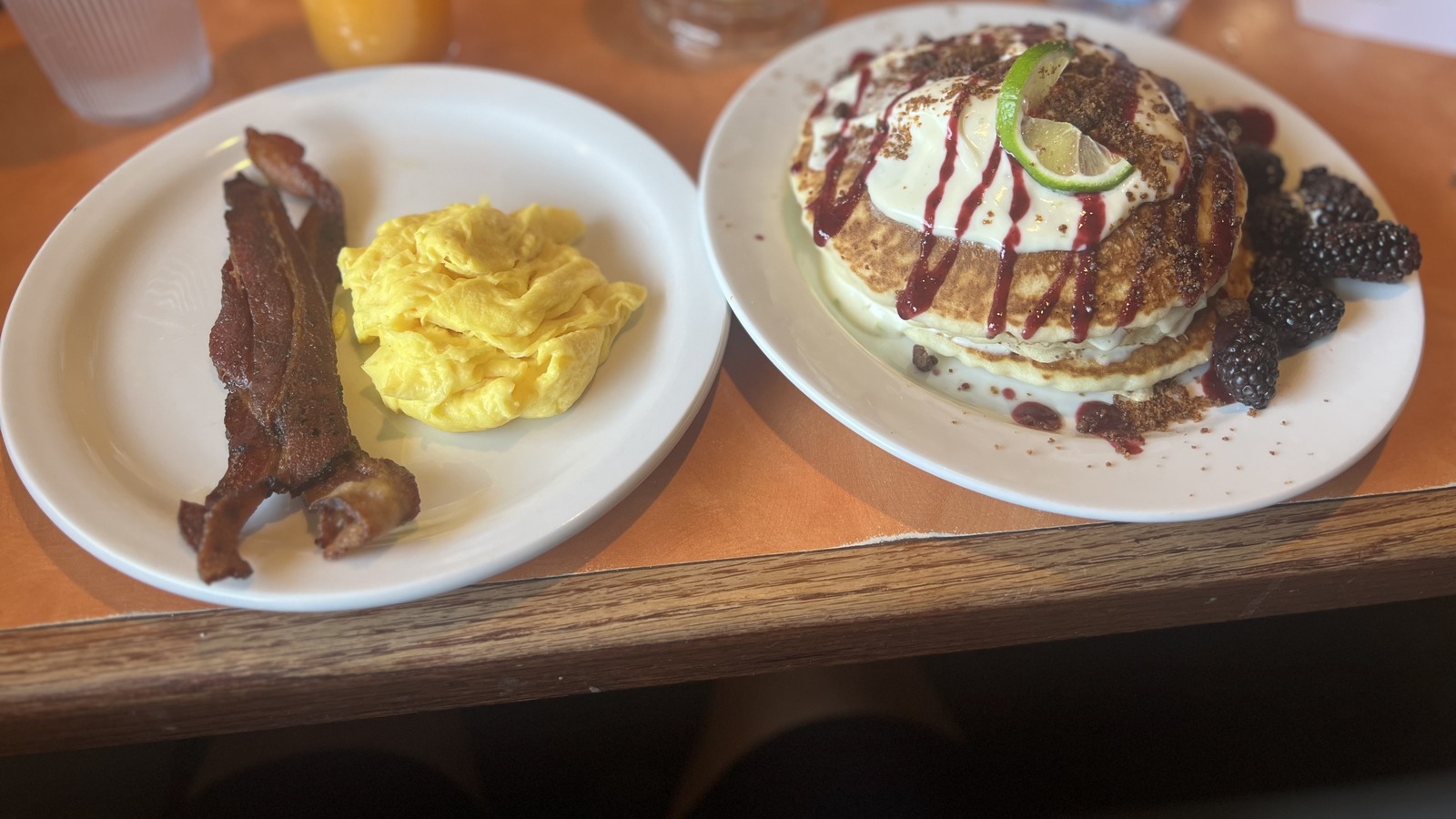 Pancakes with berry topping, scrambled eggs, and bacon at Original Breakfast House