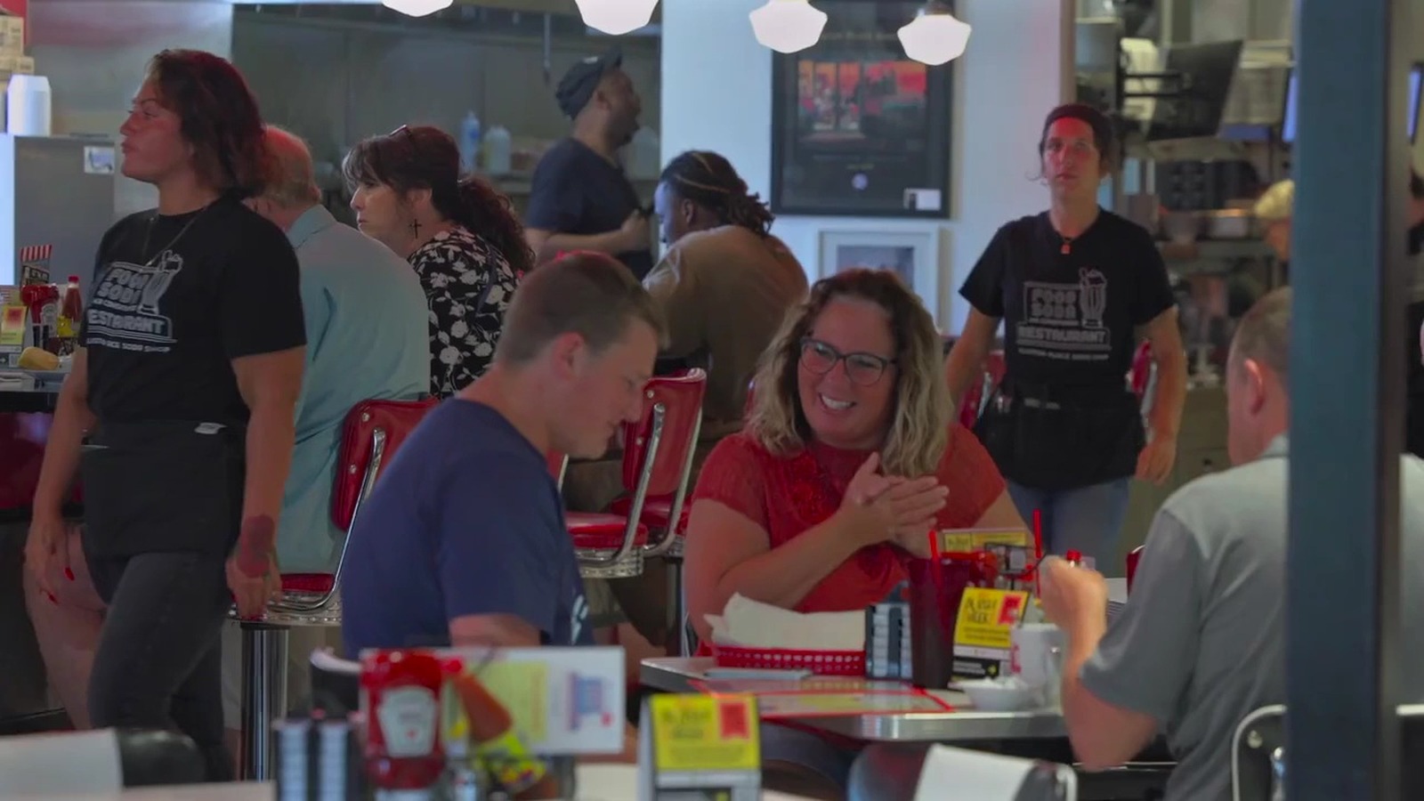 Busy lunch hour with red stools and chrome tables inside Elliston Place Soda Shop