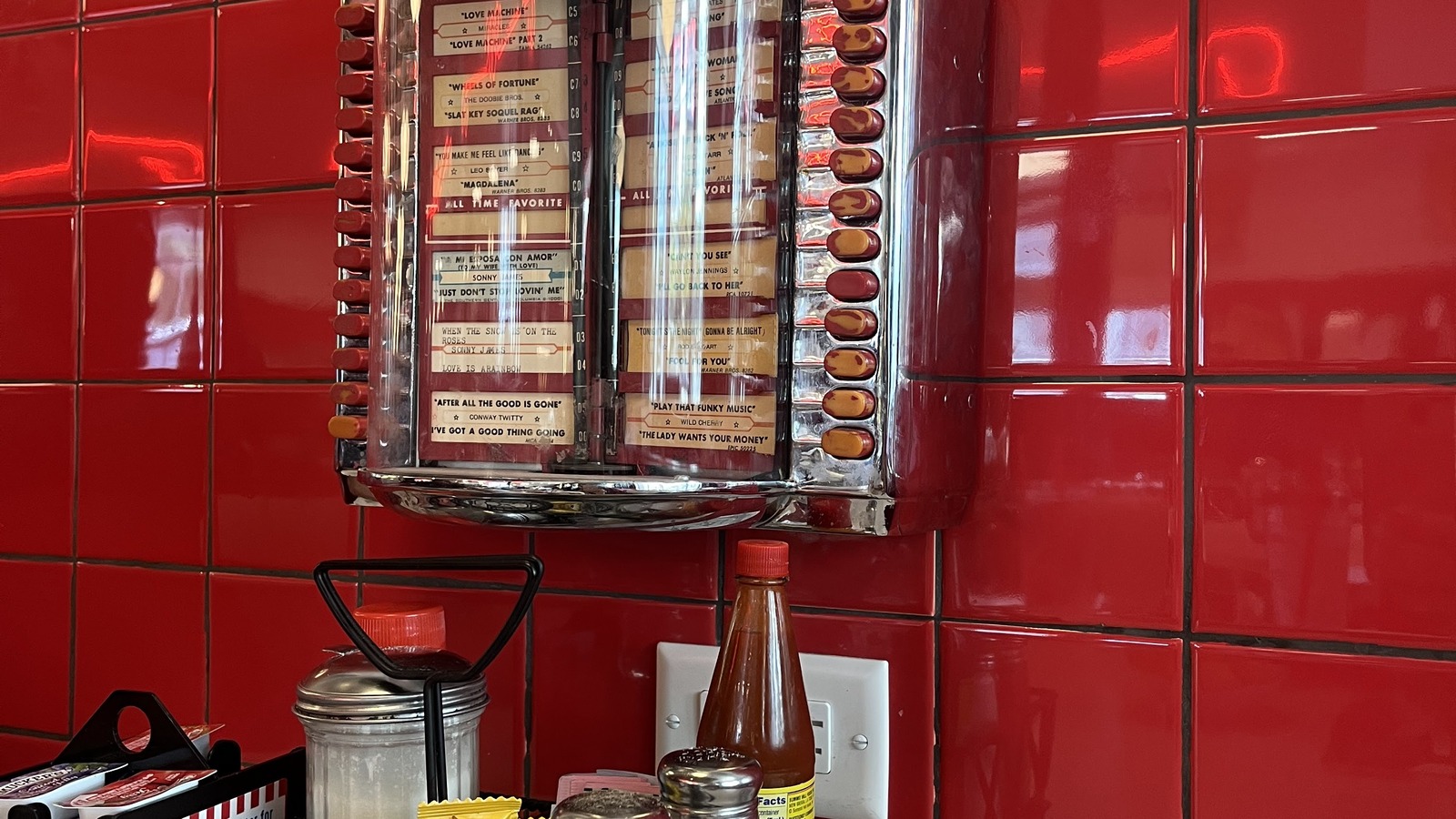 Tabletop jukebox against glossy red tile inside Elliston Place Soda Shop