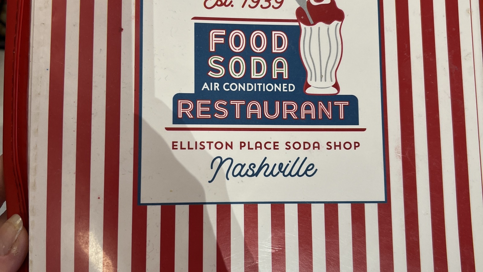 Red-and-white striped Elliston Place Soda Shop menu cover marked Est. 1939
