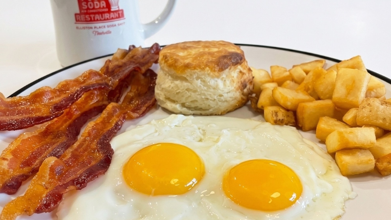 Two eggs with bacon, biscuit, and breakfast potatoes at Elliston Place Soda Shop