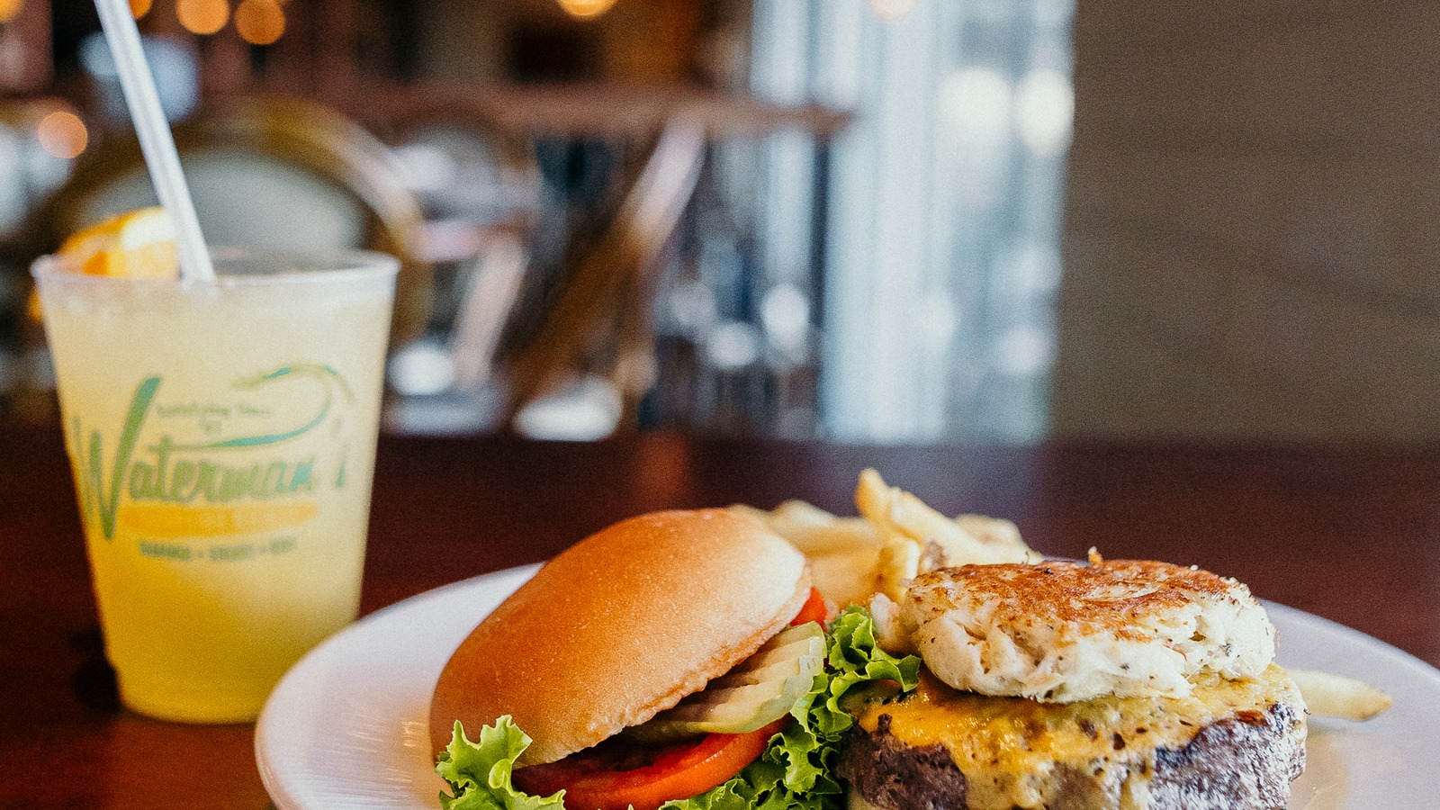 Waterman's Orange Crush beside a crab cake sandwich and fries