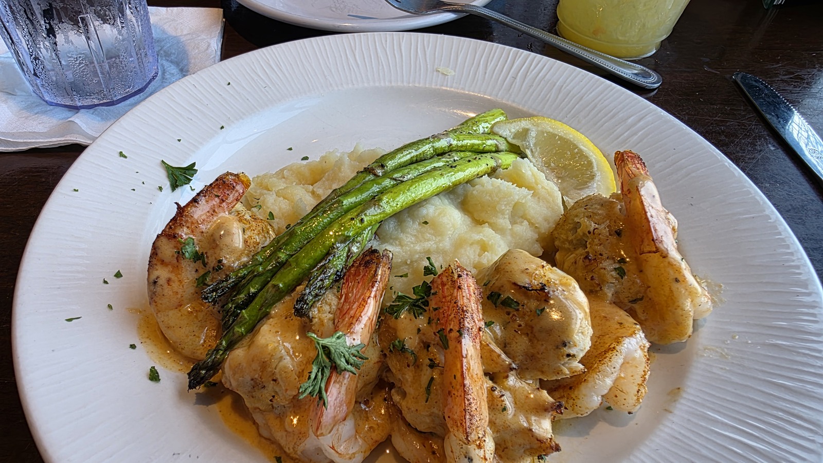 Rich seafood entree with mashed potatoes, asparagus, and lemon at Waterman's Surfside Grille