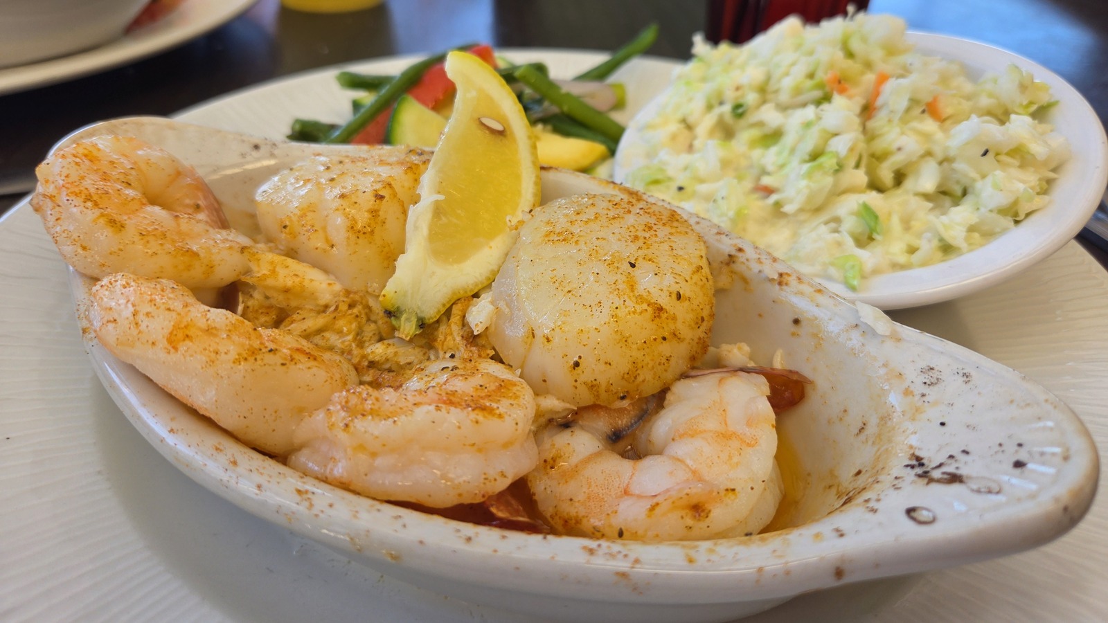 Shrimp and scallops plate with coleslaw and vegetables at Waterman's Surfside Grille