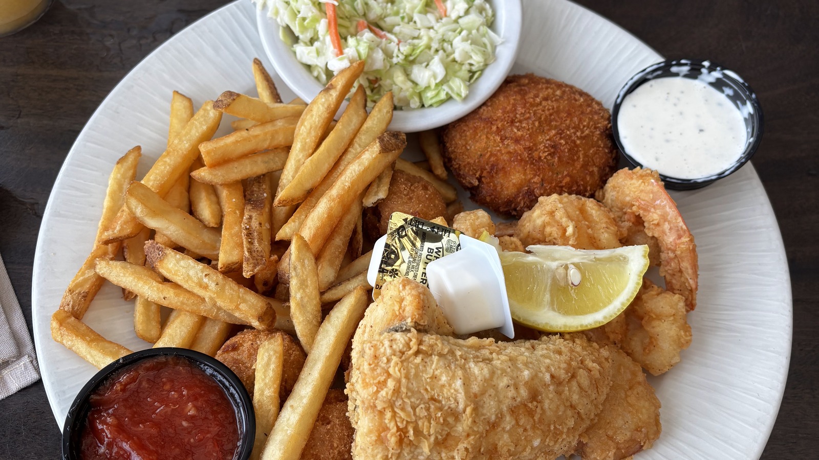 Fried seafood platter with fries, hushpuppies, and tartar sauce at Waterman's Surfside Grille
