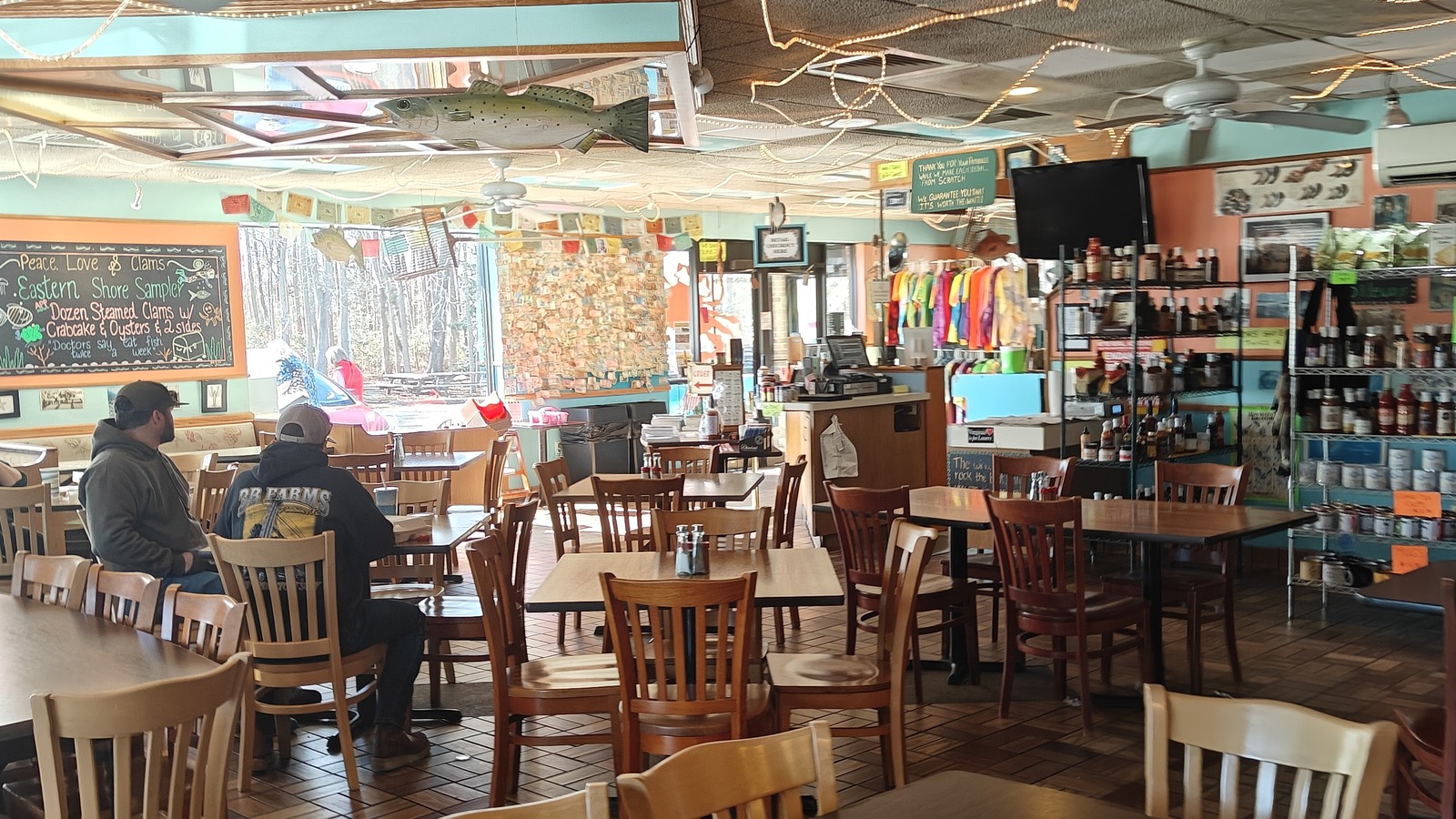 Colorful dining room with wooden tables and string lights inside The Great Machipongo Clam Shack