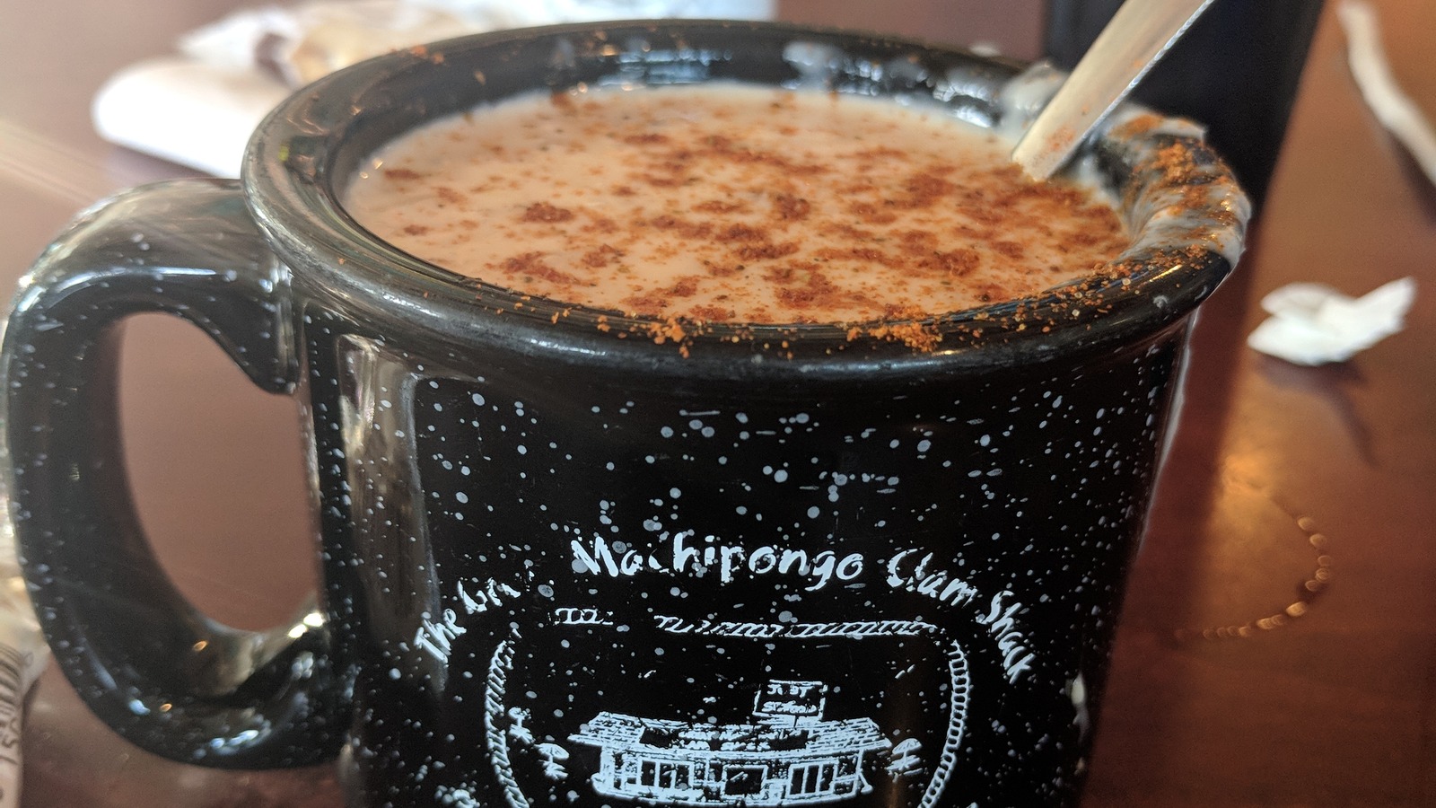 Black Clam Shack mug filled with chowder on a dining room table