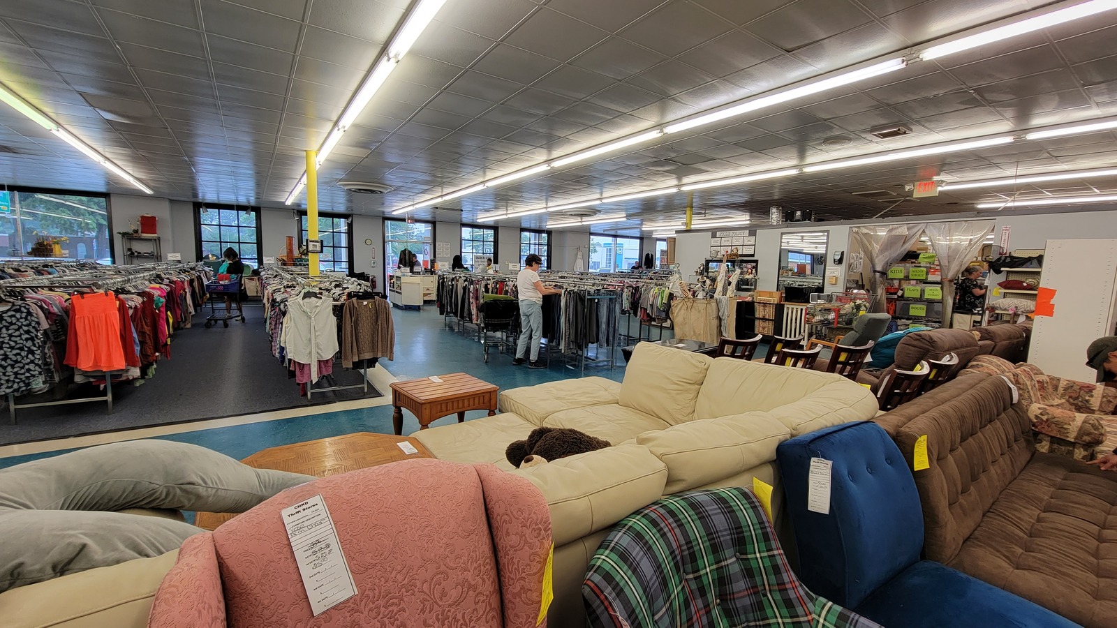 Open sales floor with sofas and clothing aisles inside CHKD Thrift Store in Virginia Beach