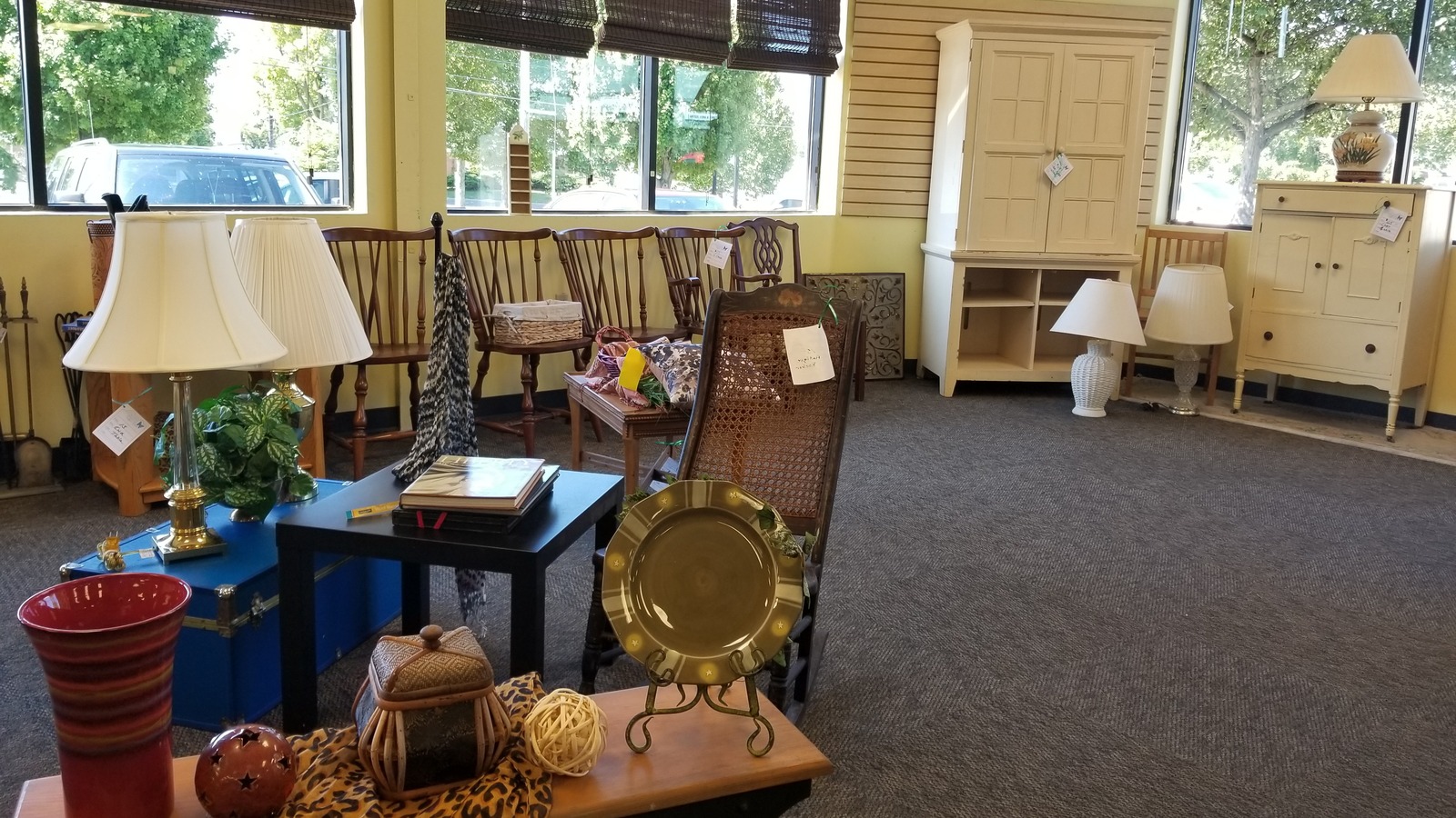Window-side furniture and home decor inside Blue Ridge Care Winchester Thrift Shop