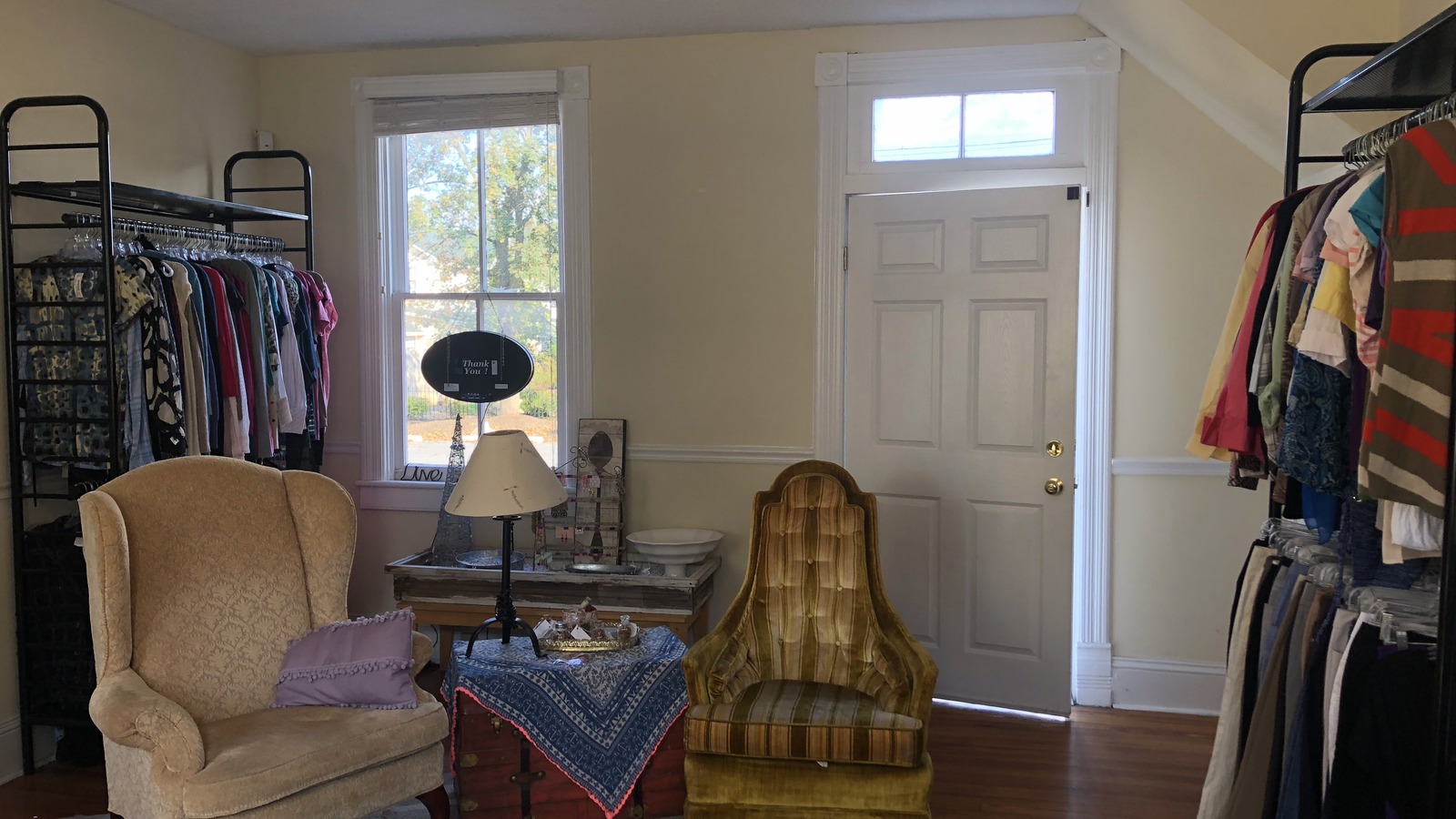 Front room with chairs, clothing racks, and natural light inside Twice Is Nice in Winchester