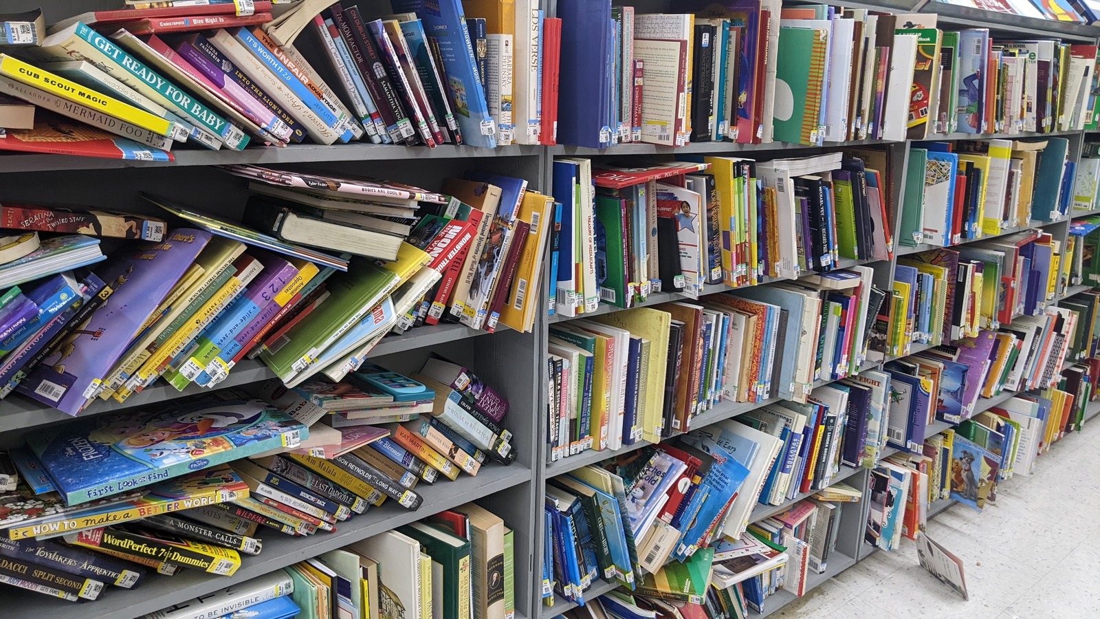 Long book aisle and clothing racks inside Texas Thrift Harlingen
