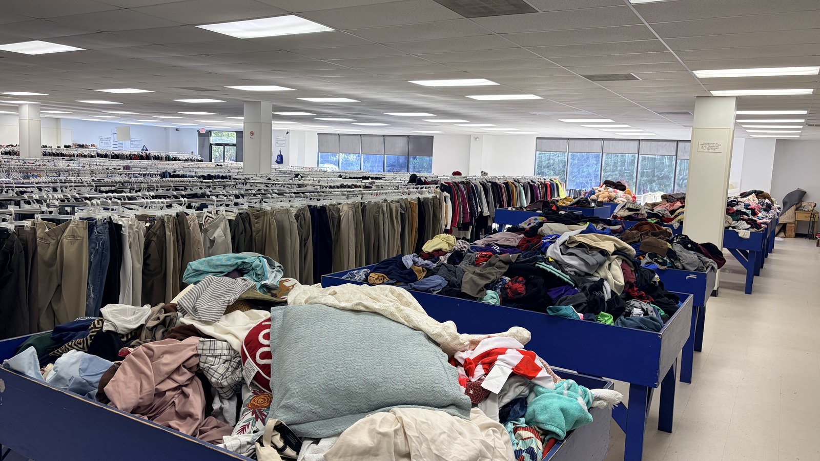 Rows of clothing and sorting bins inside the Cary Goodwill store