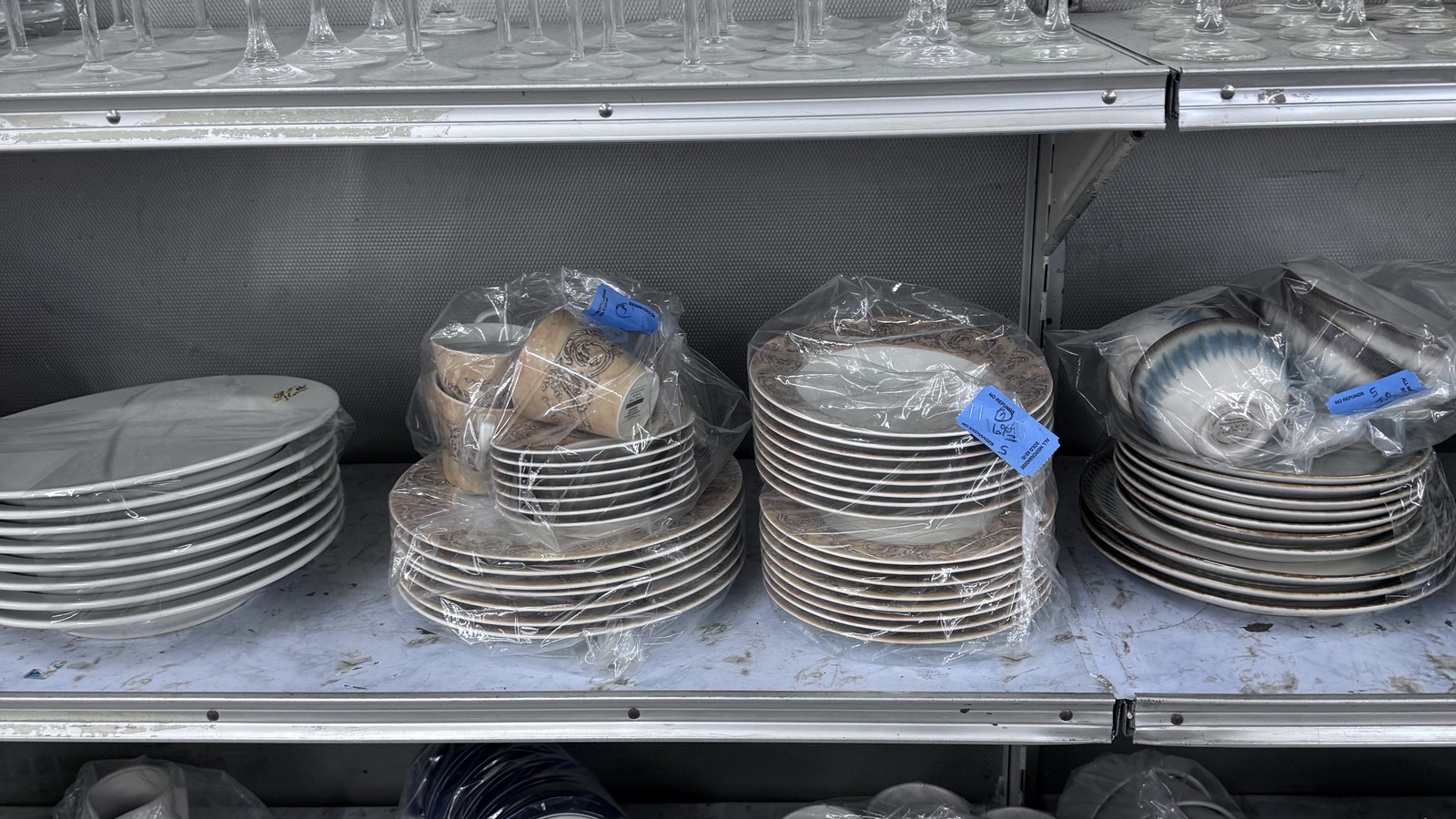 Shelves of plates and serving pieces inside Community Thrift Store