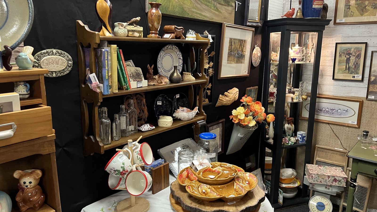 Layered shelves of dishes, books, framed art, and vintage decor inside Vintage Marketplace in Fort Collins