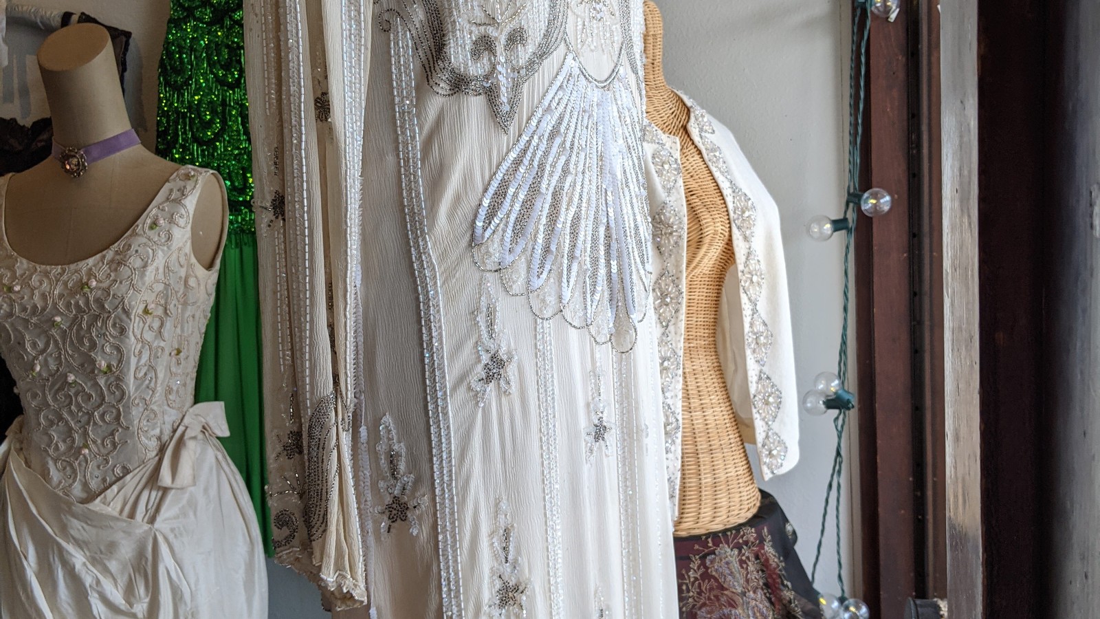 Cream and silver vintage gowns hanging inside Wear It Again, Sam in Fort Collins