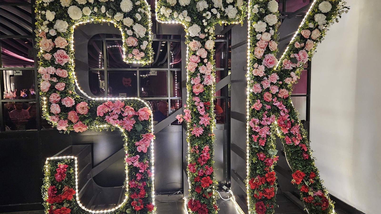 Large floral STK letters lit with white lights inside the Orlando restaurant