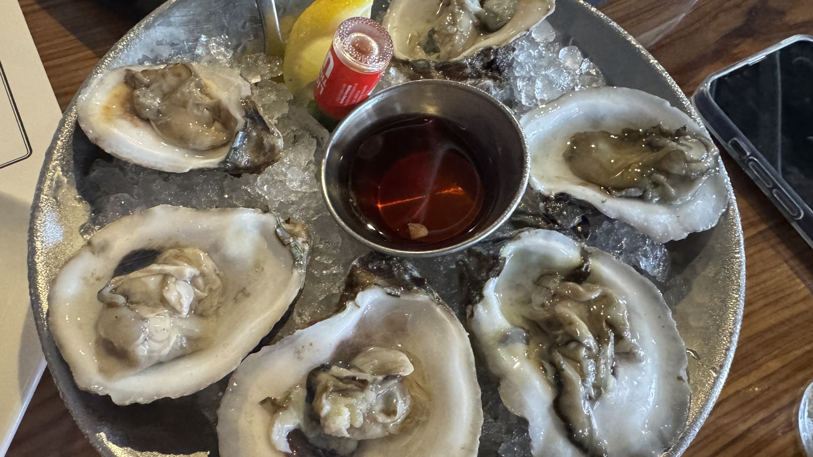 Plate of chilled oysters on ice at STK Steakhouse in Orlando with lemon and mignonette