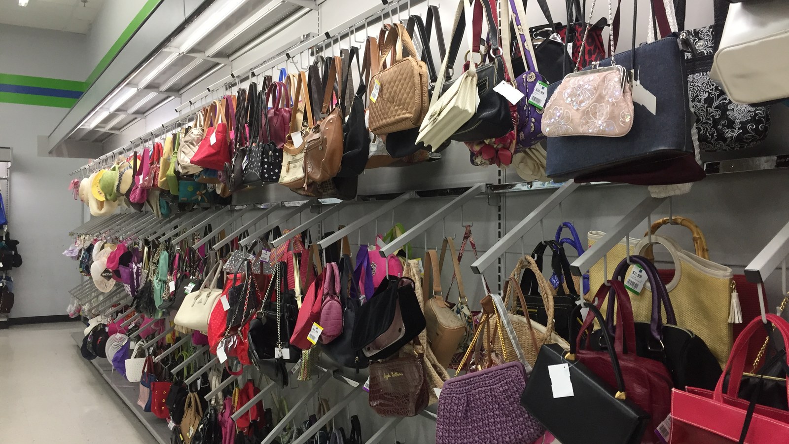 Large wall of colorful secondhand handbags at 2nd Ave in Laurel