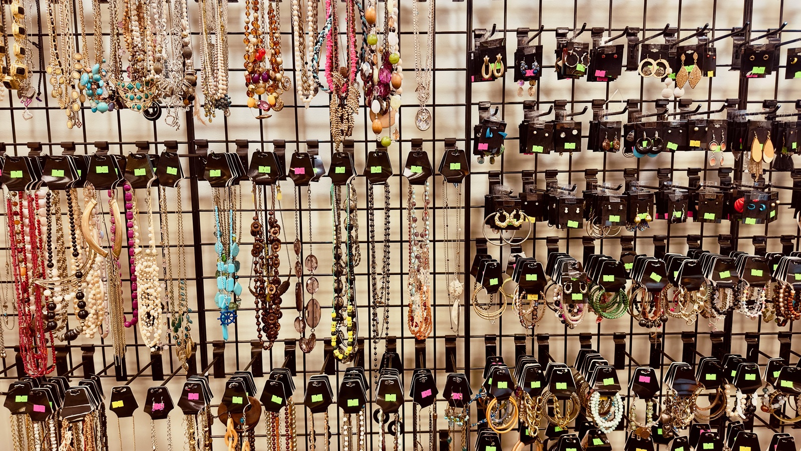 Necklaces, bracelets, and earrings arranged in the jewelry display at New Life Thrift