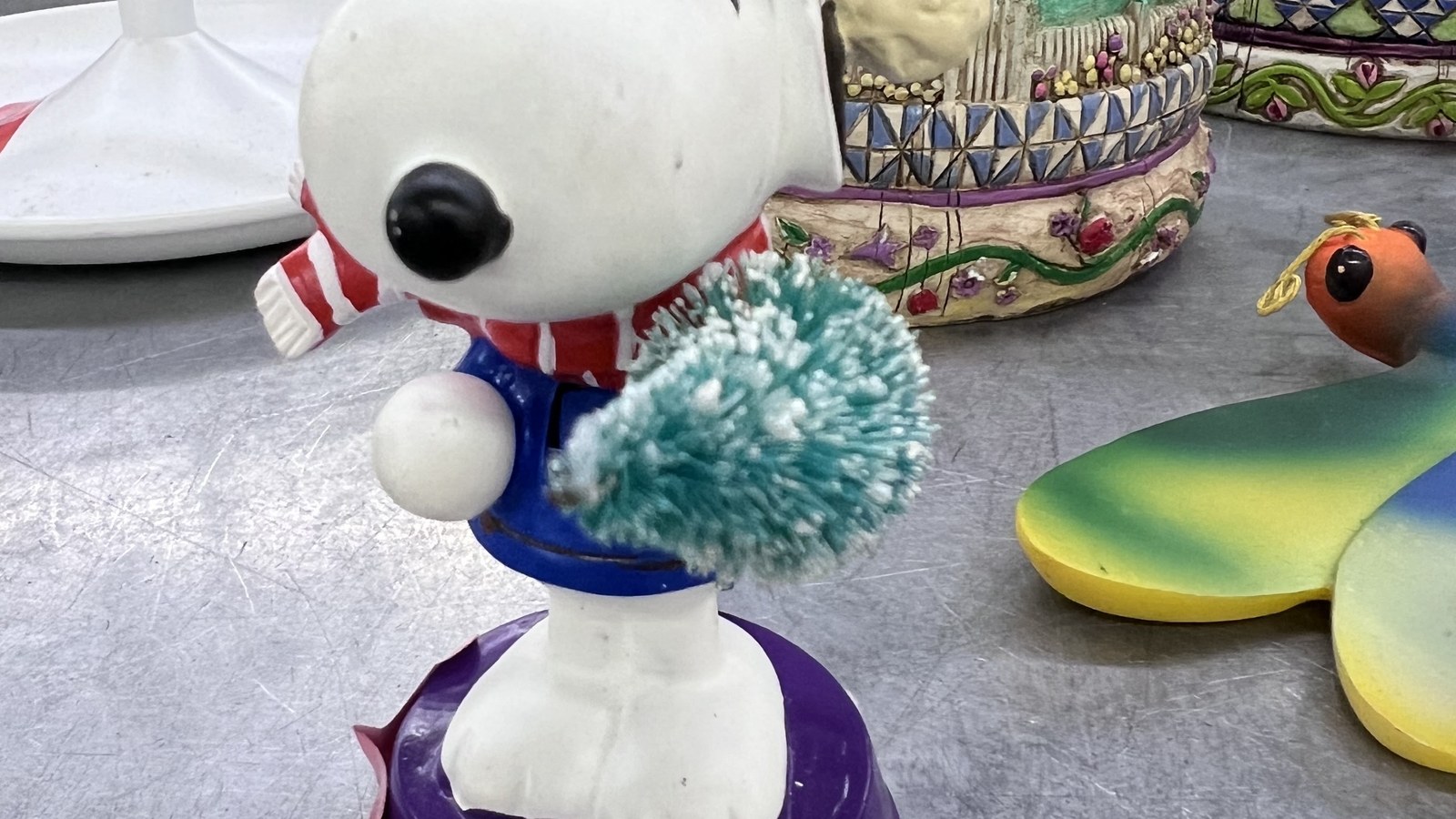 Snoopy figurine among colorful collectibles at the Hialeah thrift store