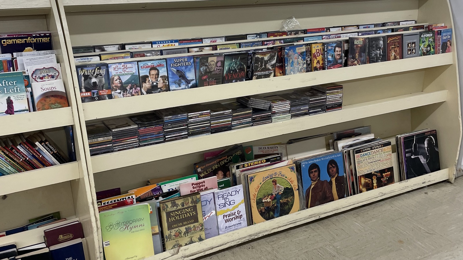Books movies and music arranged on secondhand media shelves