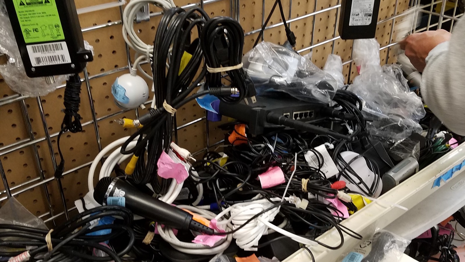 Electronics cords and accessories arranged on pegboard