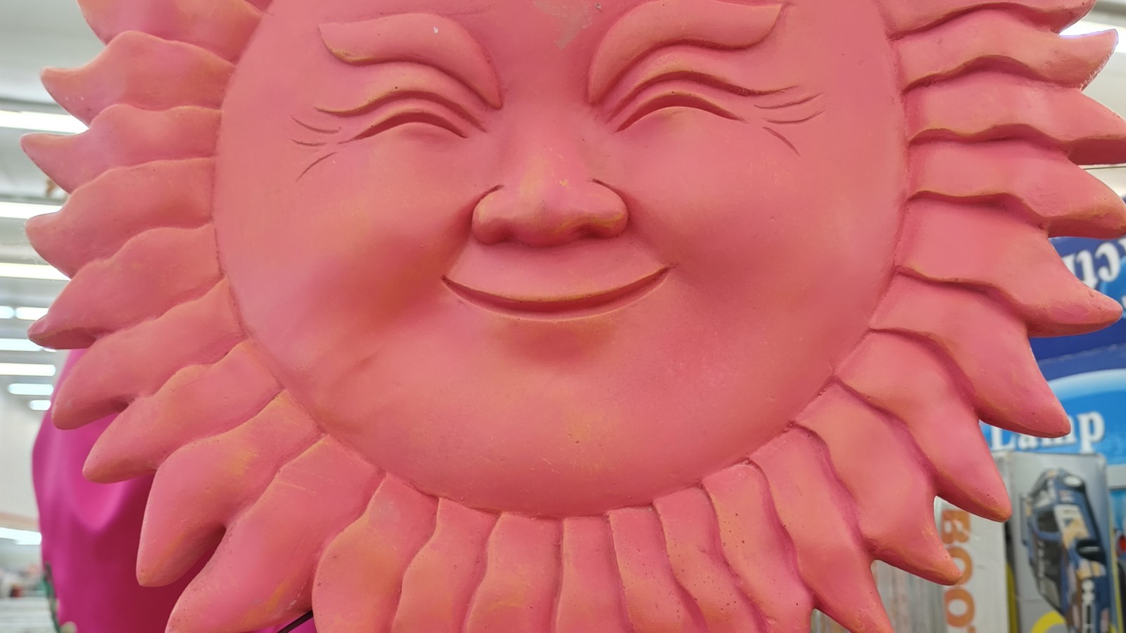 Bright pink sun wall decoration on the thrift-store floor